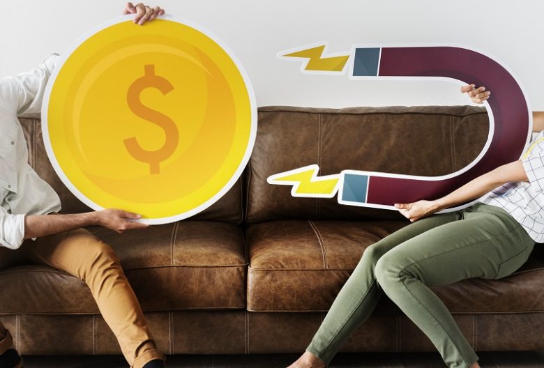 Magnet attracting huge gold coin with money sign