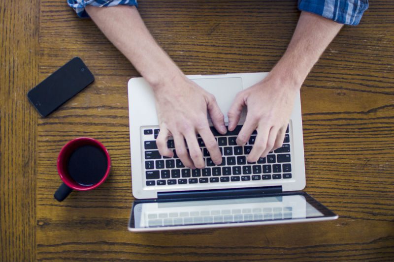 Man working on laptop drinking coffee