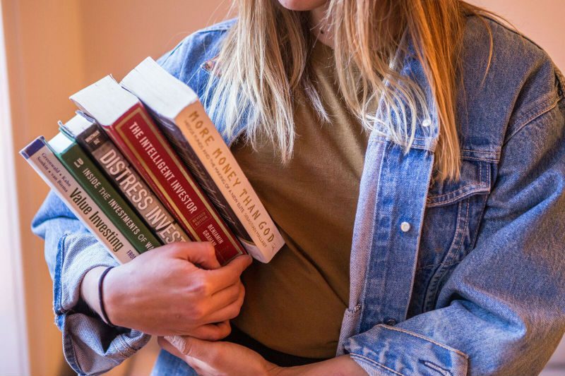 Woman carrying investing and finance books
