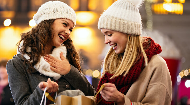 two young ladies shopping for holiday discounts