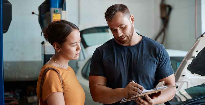 Young woman paying for auto repairs after reading Sunbit review.