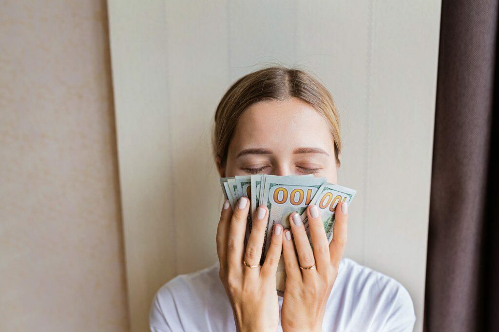 woman holding cash to her face