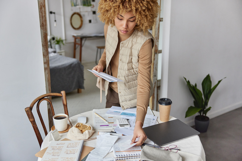 Young woman collecting her financial paperwork after reading Best Egg personal loans review.