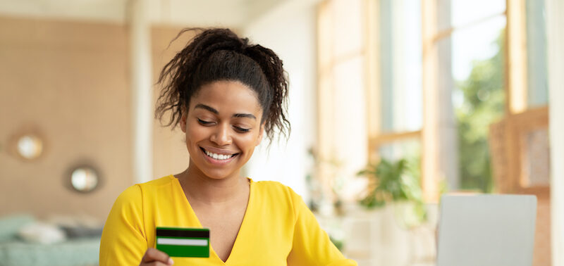 young woman at computer looking up the best ways to borrow money.