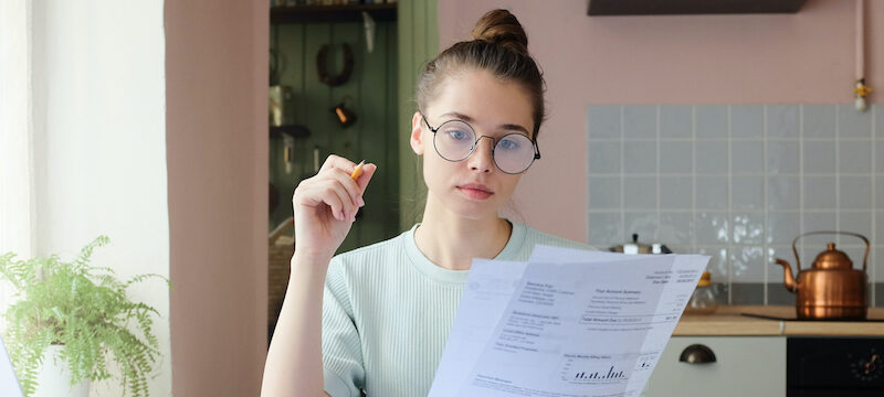 Young woman filling out an application after deciding between a personal loan vs credit card.