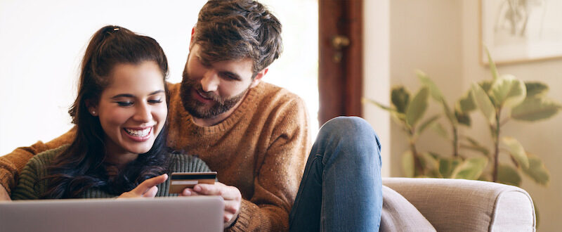 Couple holding their new card after learning how to get a credit card.