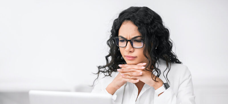 Woman sitting at computer trying to research the answer to, "How many credit cards should I have?"