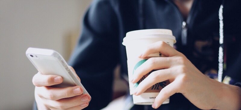 Person holding coffee that they got after earning a free Starbucks gift card.
