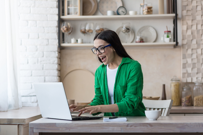 Woman reading a positive Charitybuzz review on her laptop.