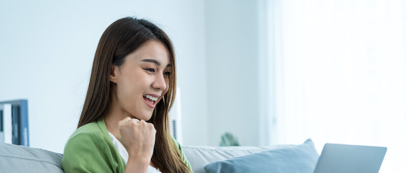 Young woman excited about how much extra money she made after using a Survey Junkie hack.