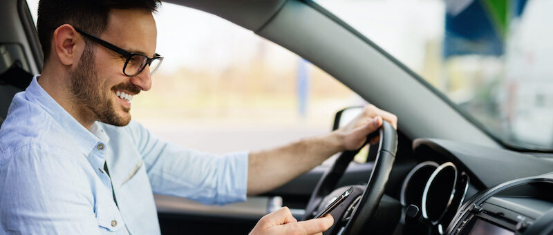 Man looking happy after saving money on gas by reading an Upside app review.