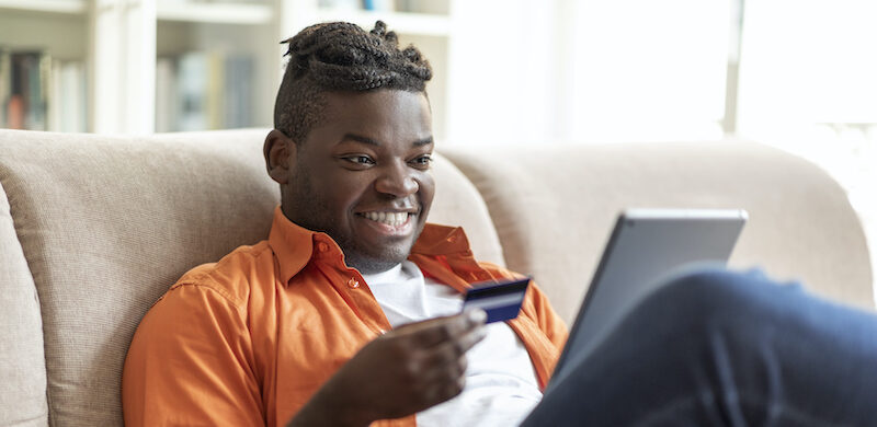 Young man reading a Quontic Bank review online.