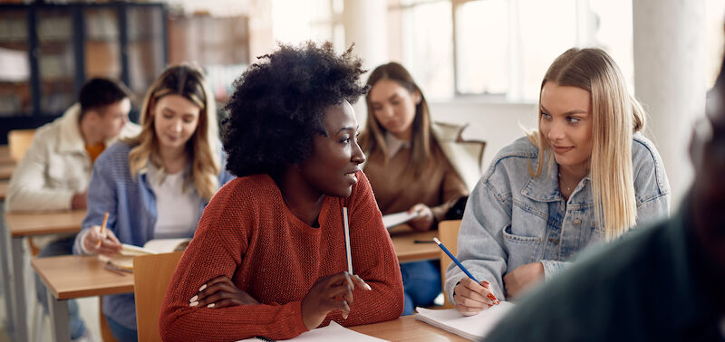 Female college students discussing the Sallie Mae review they just read.