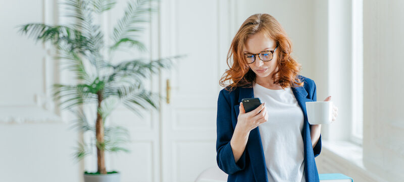 A woman reading a Raisin review online while searching for a new bank.