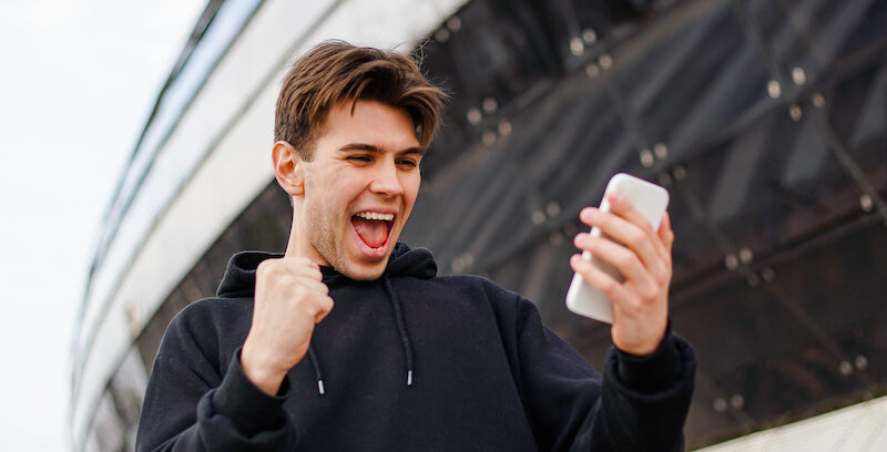 Young man is excited after learning the answer to, "Is Blackout Bingo legit?"
