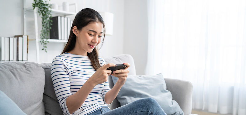 Young lady reading a Solitaire Cash review online.