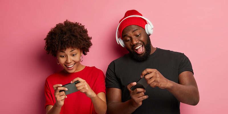 Two people playing games to earn money with Cash Giraffe.