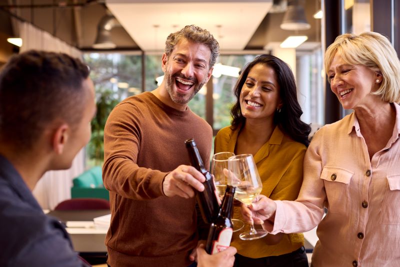 Smiling people with wine glasses and a wine bottle