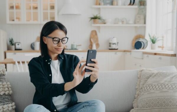 Woman sitting on sofa looking at cell phone