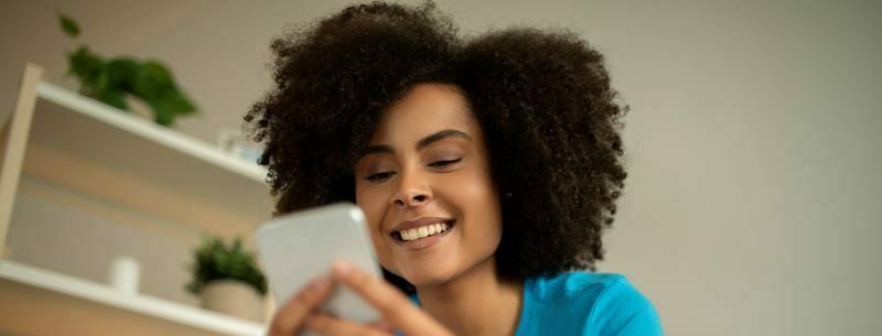 Woman looking at cell phone smiling