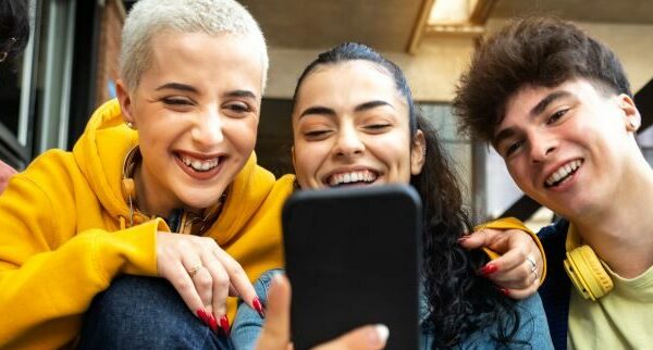 Teens smiling looking at cell phone