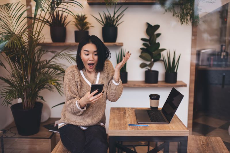 Excited woman looking at phone