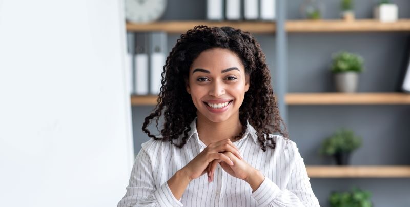 Professional woman seated at desk smiling