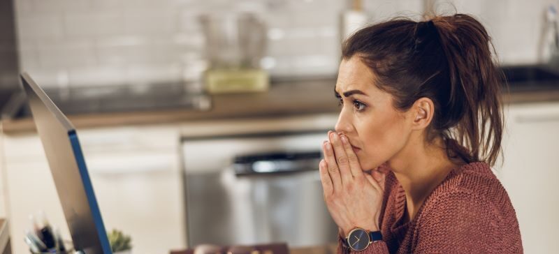 Upset woman looking at home computer